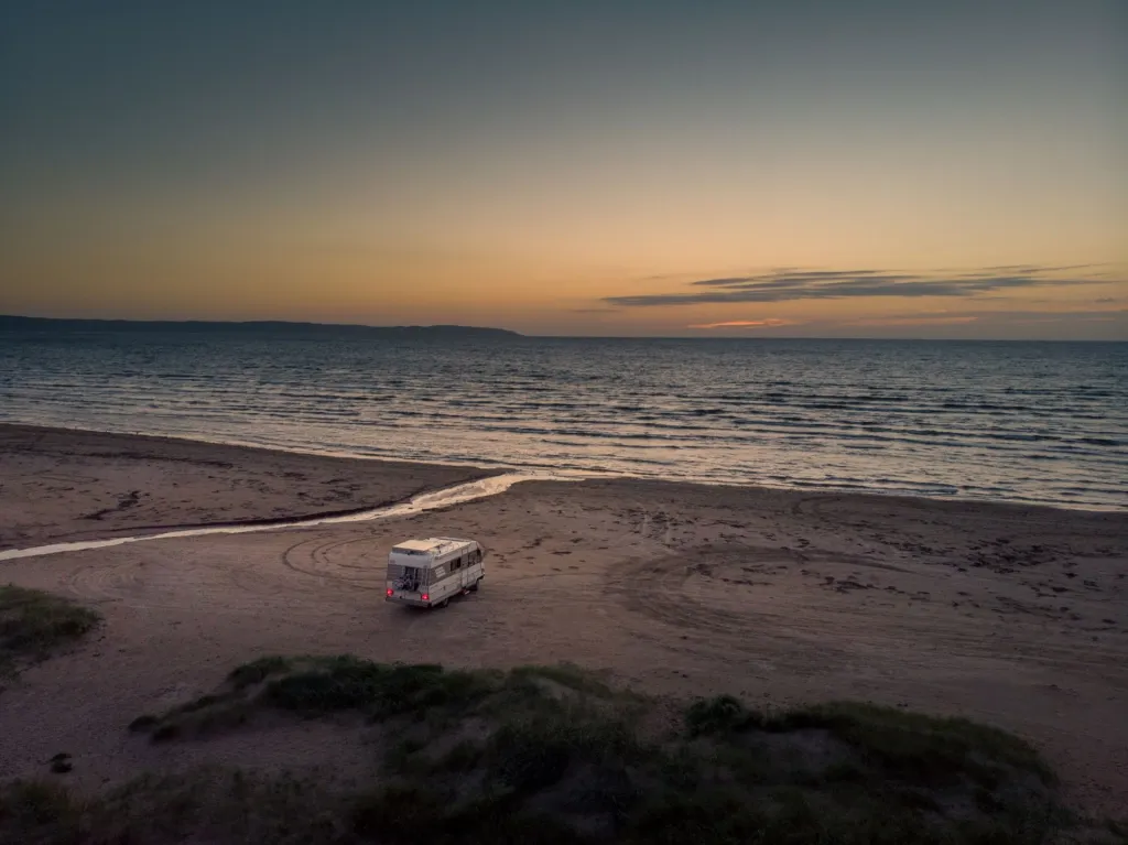 Camper by the sea at sunset